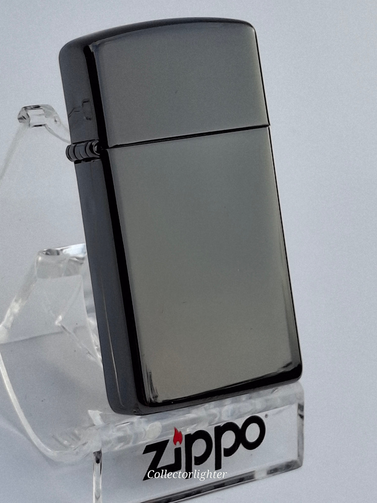 Zippo Ebony Slim Line 60001260, schräge Vorderansicht mit schwarzgrauem Hochglanzgehäuse und Scharnier