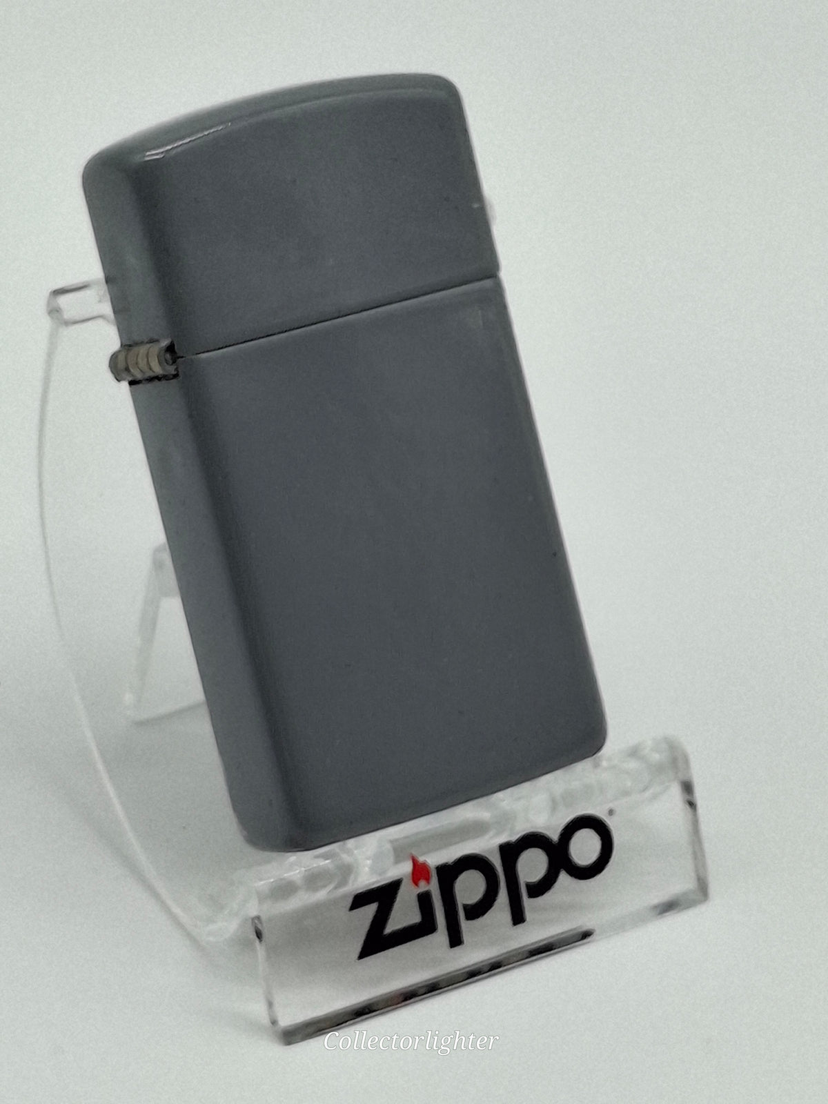 Zippo Flat Gray Slim Line, schräge Vorderansicht mit schmalem grauem Gehäuse und Scharnier