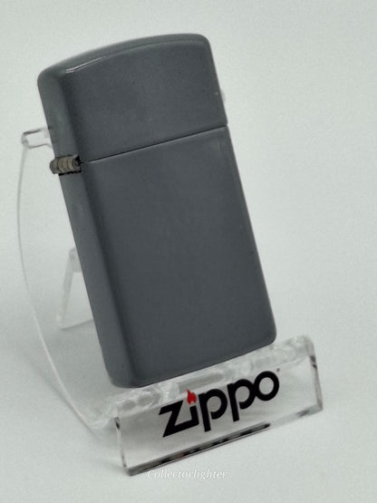 Zippo Flat Gray Slim Line, schräge Vorderansicht mit schmalem grauem Gehäuse und Scharnier