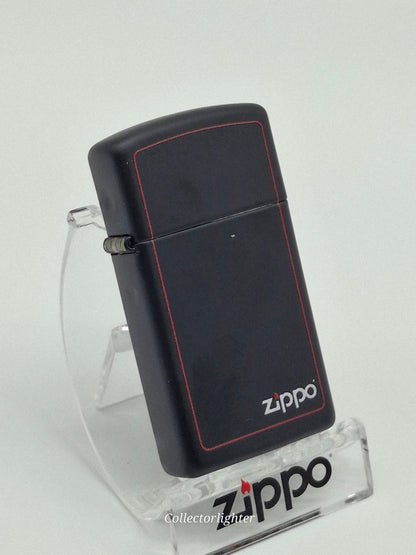 Zippo Black Matte with Zippo Border Slim Line 60001438, schräge Vorderansicht mit mattschwarzem Gehäuse, rotem Rahmen und Zippo-Logo